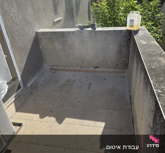 מיכל נוזל וכלי עבודה על מעקה מרפסת